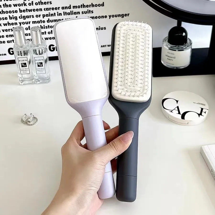 Self-cleaning hair brush with rotating handle, anti-static teeth and scalp massage points in purple and grey colours