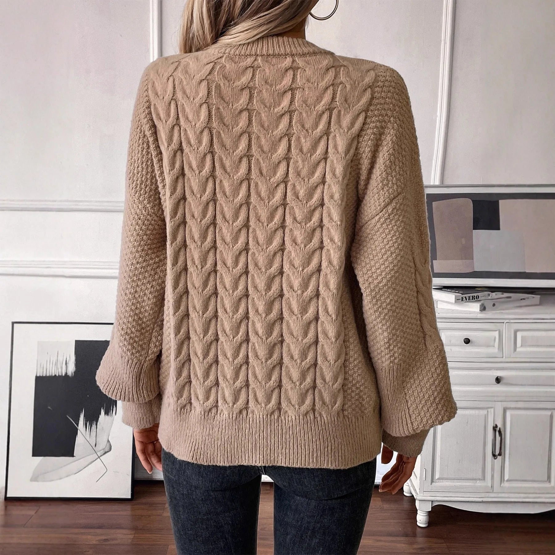 Women's loose beige round neck sweater showing twisted texture detail on the front.