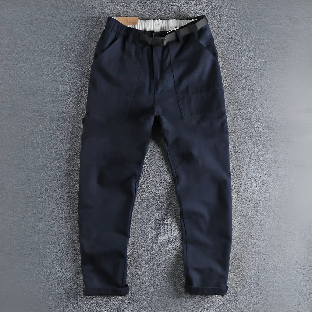 Men's khaki cotton work trousers with N I buckle belt showing three-dimensional cutting and mid waist design