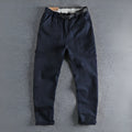 Men's khaki cotton work trousers with N I buckle belt showing three-dimensional cutting and mid waist design