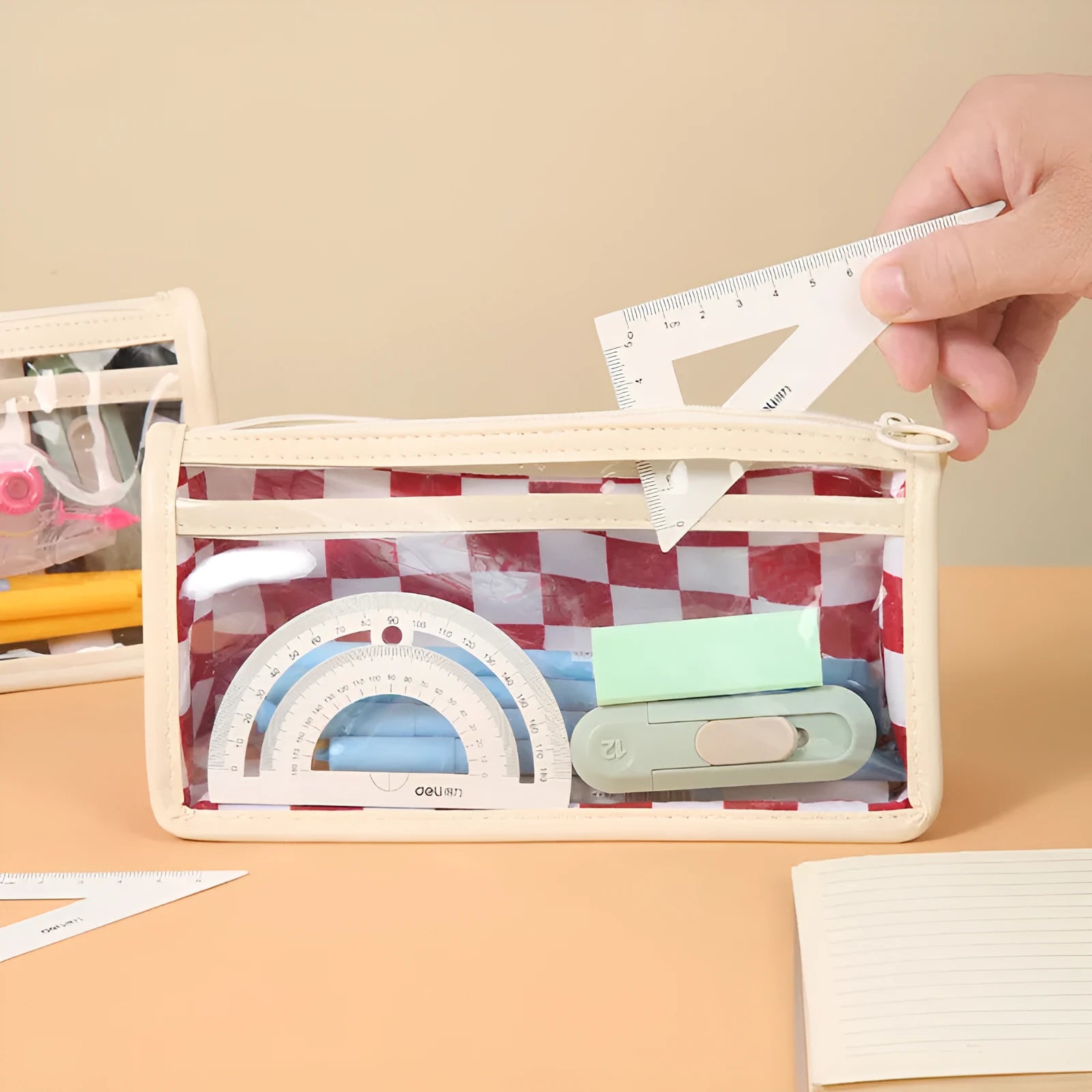 Large transparent PVC pencil case with a chessboard pattern, showing pens inside.