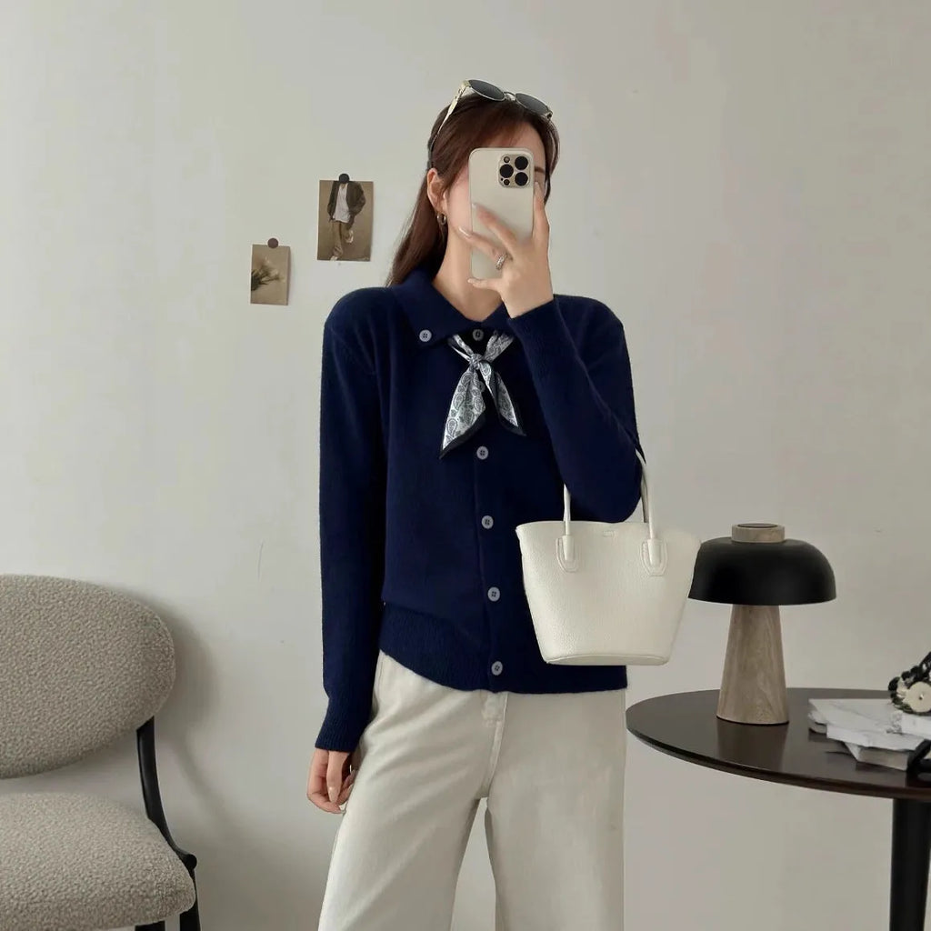 Beige cardigan sweater with attached lapel scarf and long sleeves on a model.