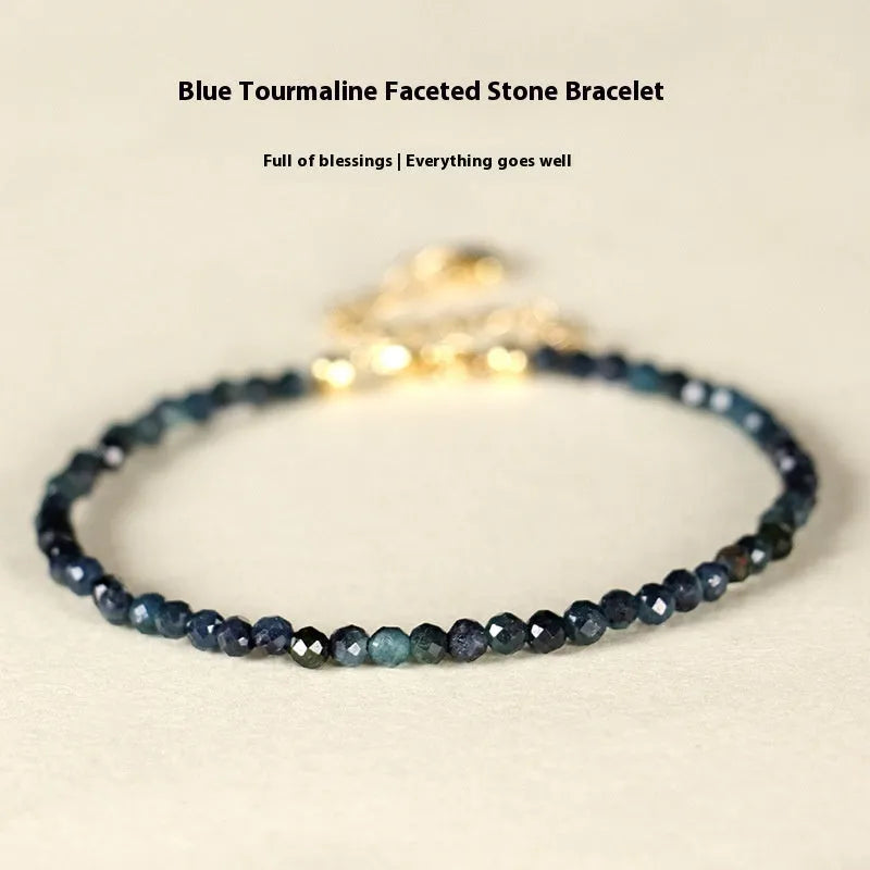 Close-up of a women's blue tourmaline gemstone beaded bracelet with 3mm beads and spacer design.