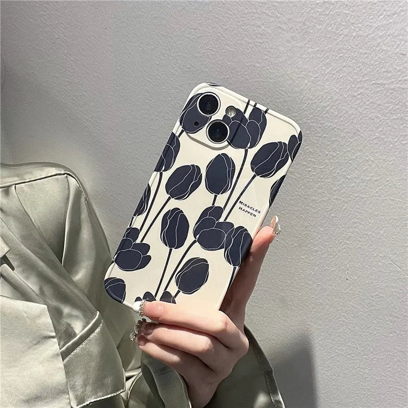 Black silicone iPhone case with a white tulip pattern design on the back.