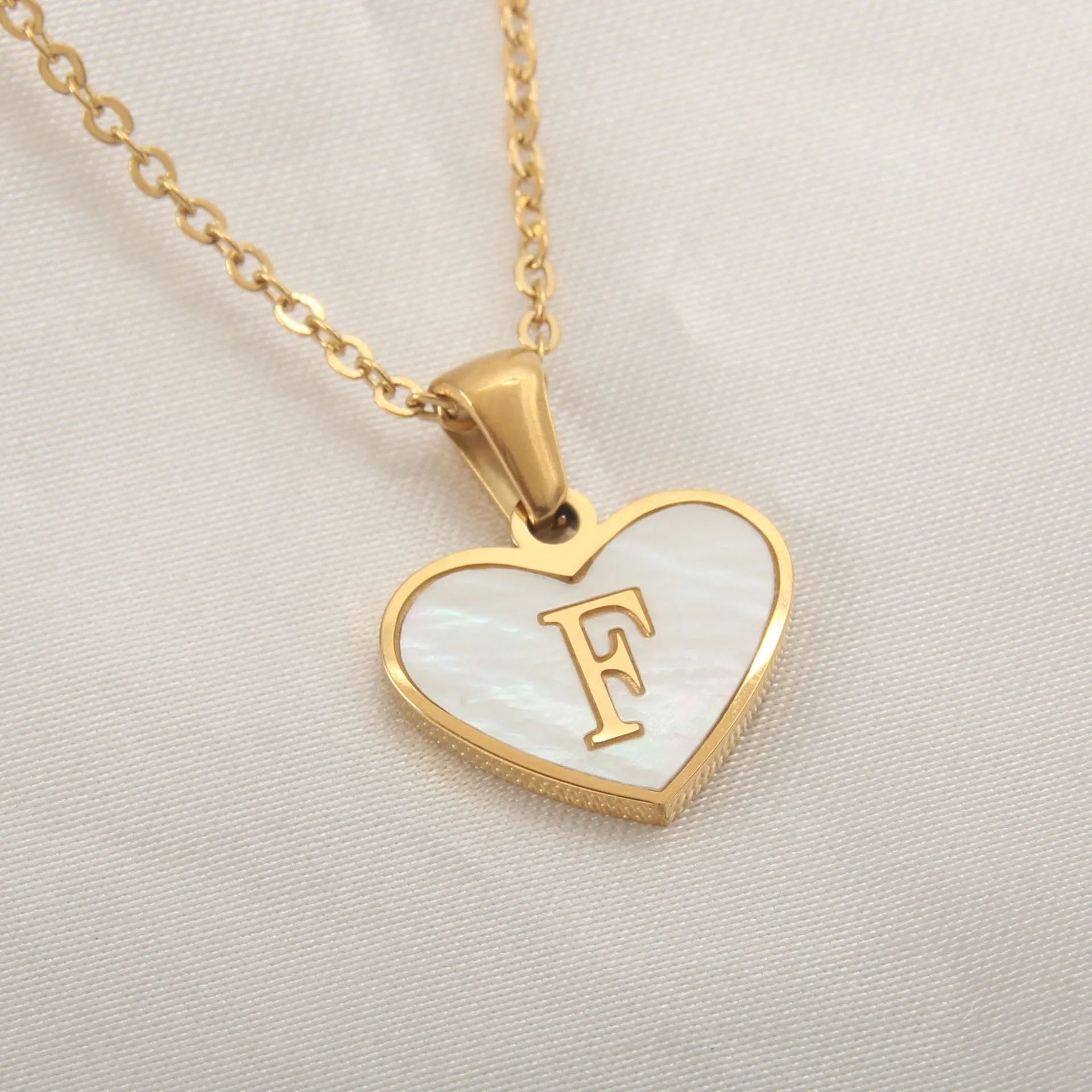 Gold plated heart-shaped white shell pendant personalised initial necklace on a stainless steel chain.