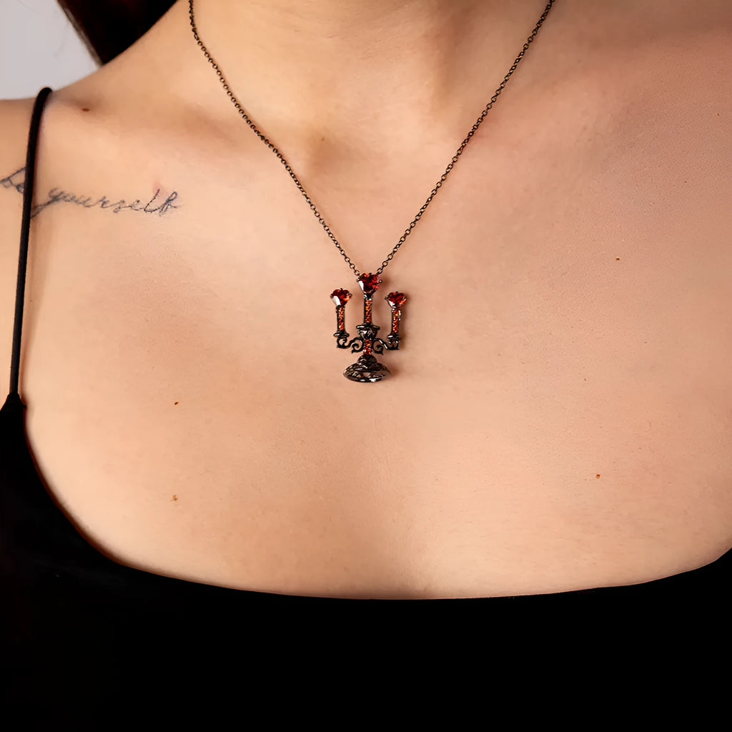 Close-up of a retro-style hollow candlestick pendant necklace with a cross chain, in a gothic design.