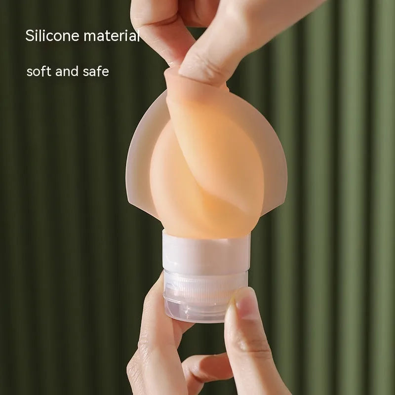 Three silicone travel storage bottles in mixed colours with stickers on a white background