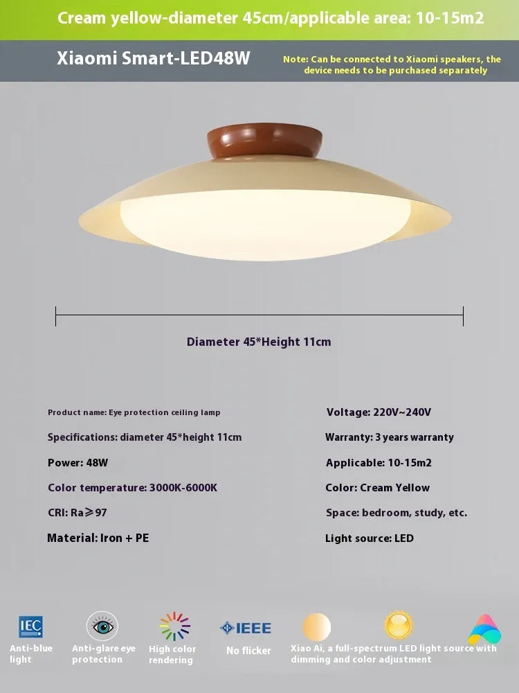 Modern minimalist flying saucer design ceiling lamp in cream yellow on a white ceiling.