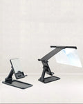 Black folding mobile phone screen magnifier with detachable holder on a desk