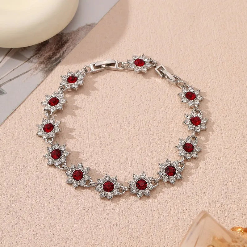Electroplated zinc alloy bracelet with flower-shaped coloured gemstone charm in gold and silver colour variations