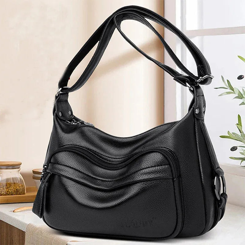 Large black PU shoulder bag with crossbody strap showing multiple internal compartments and zipper closure