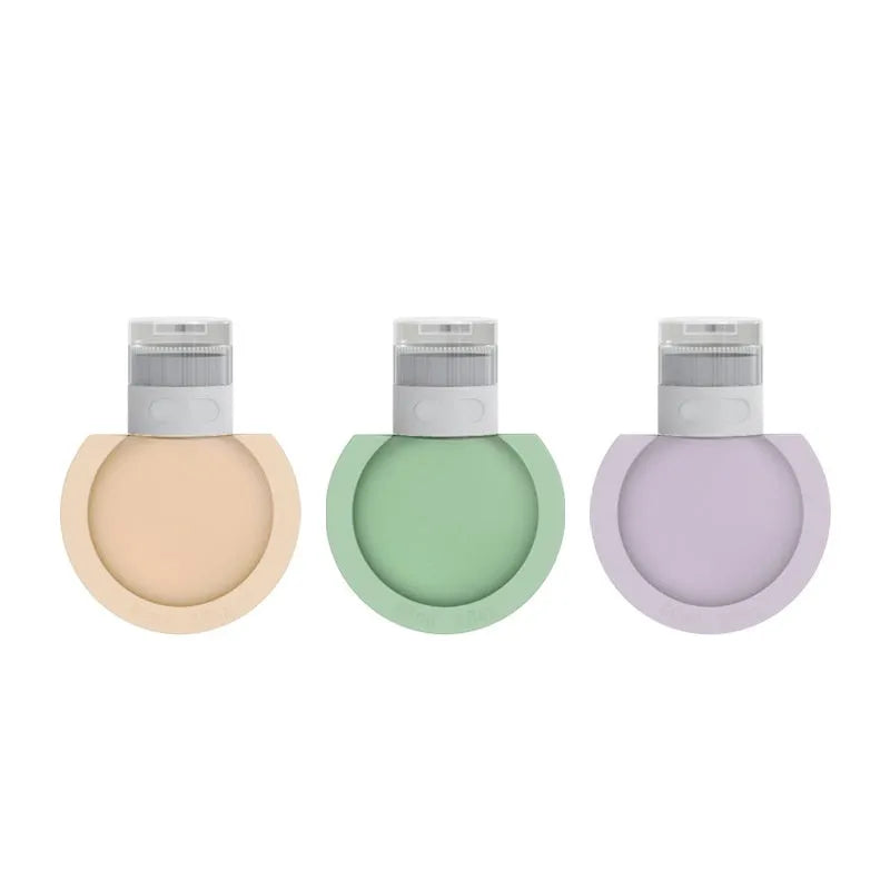 Three silicone travel storage bottles in mixed colours with stickers on a white background