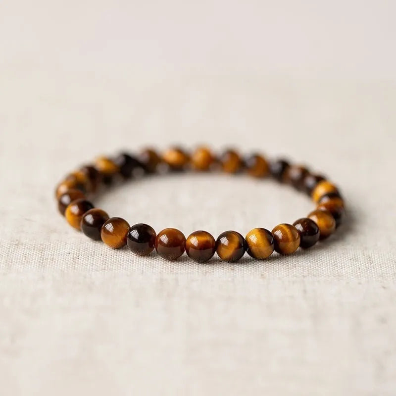 Close-up of a single-circle beaded Buddha rosary bracelet with tigereye dzi patterns on brown beads.