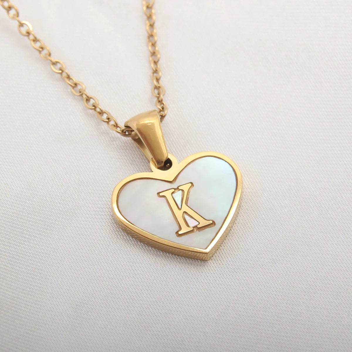 Gold plated heart-shaped white shell pendant personalised initial necklace on a stainless steel chain.