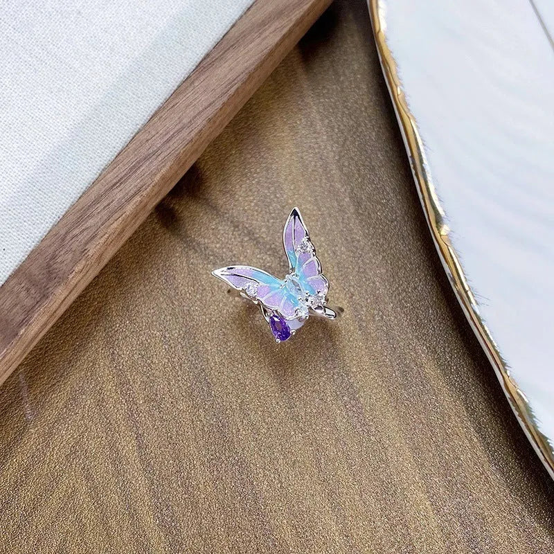 Copper insect fashion ring with adjustable band and drip oil finish on a hand.