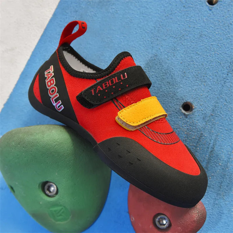 Pair of beginner rock climbing shoes with Velcro strap and black and red rubber outsole.