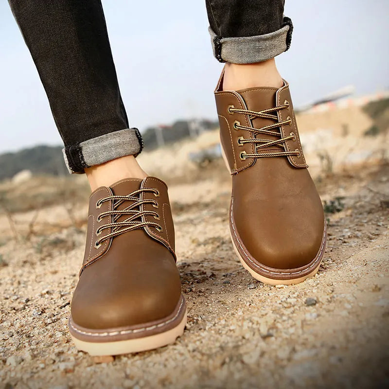 Men's black mid-top Tide British leather boots with a flat rubber sole on a neutral background.