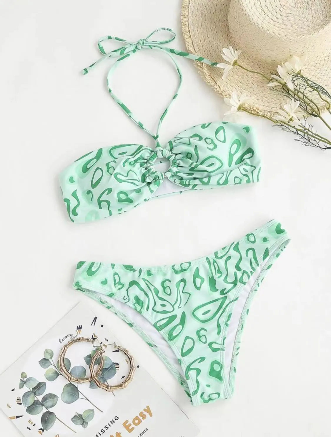 Green floral bandeau bikini swimsuit with split design on a mannequin