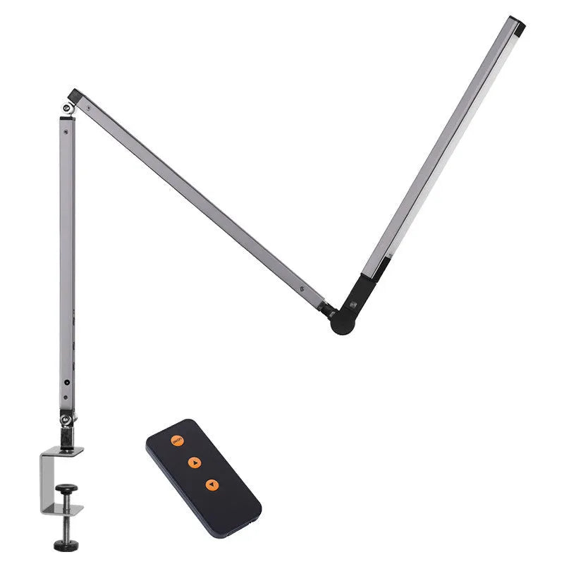 Black adjustable clip-on desk lamp with flexible arm and remote control on a wooden desk