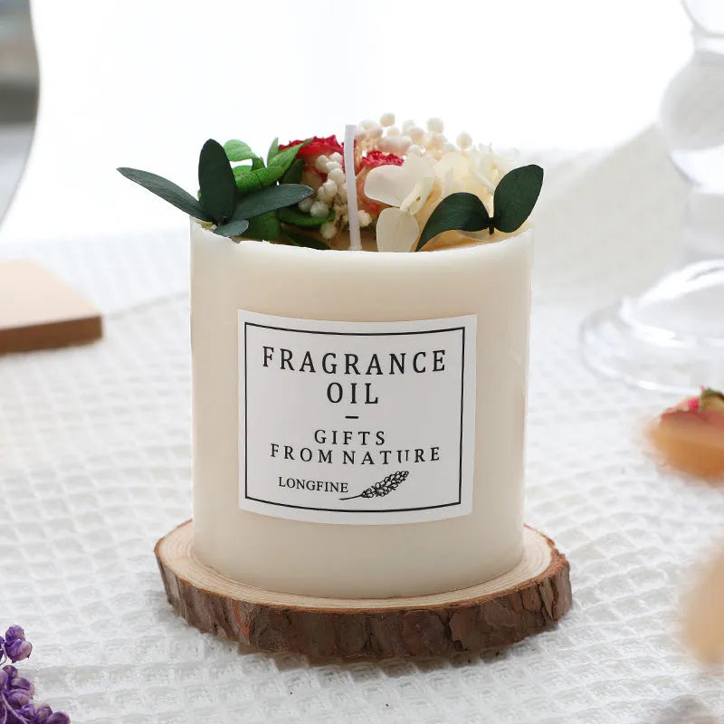 Aromatherapy candle decorated with dried flowers on top, shown in gift box packaging with a wood base.