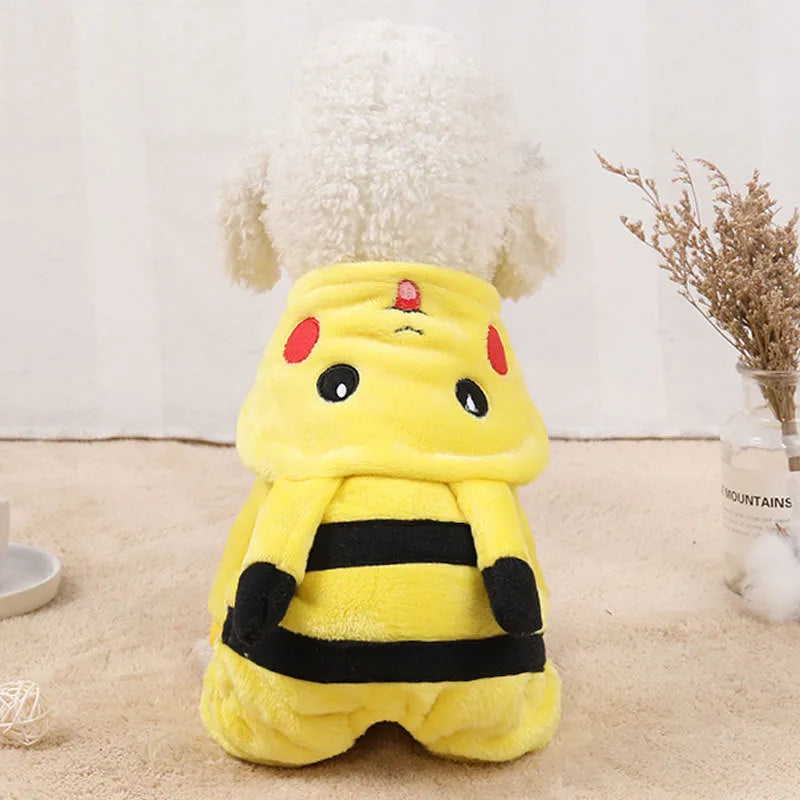 A small dog or cat wearing a cartoon-design fleece coat with a hoodie, suitable for indoor winter wear.