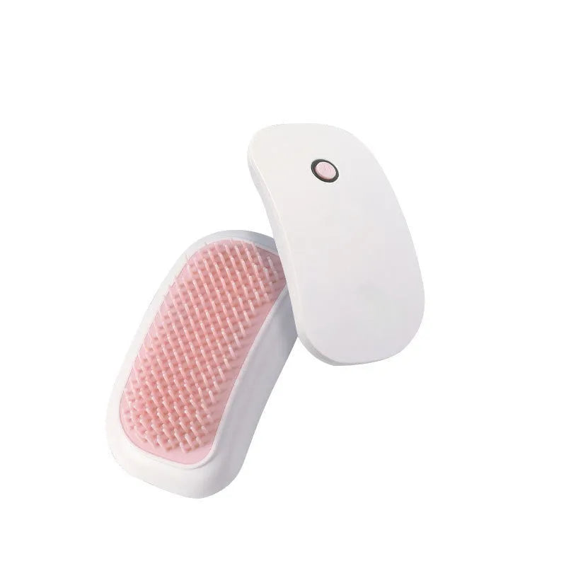 Pink handheld electric vibration pet grooming brush with soft TPE teeth on a white background.