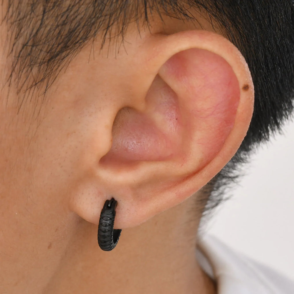 A pair of stainless steel earrings with a snake pattern design in black or gold.