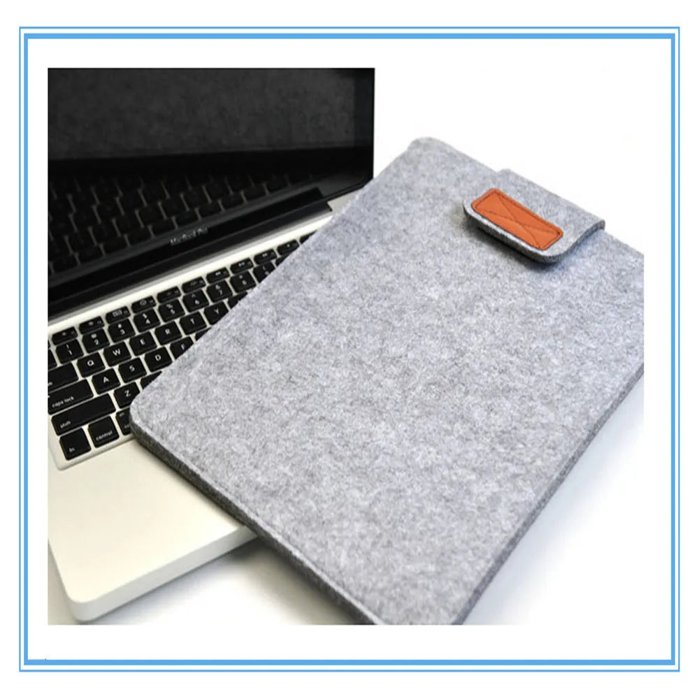 Dark grey clamshell laptop bag open to show interior laptop compartment and corner protector.