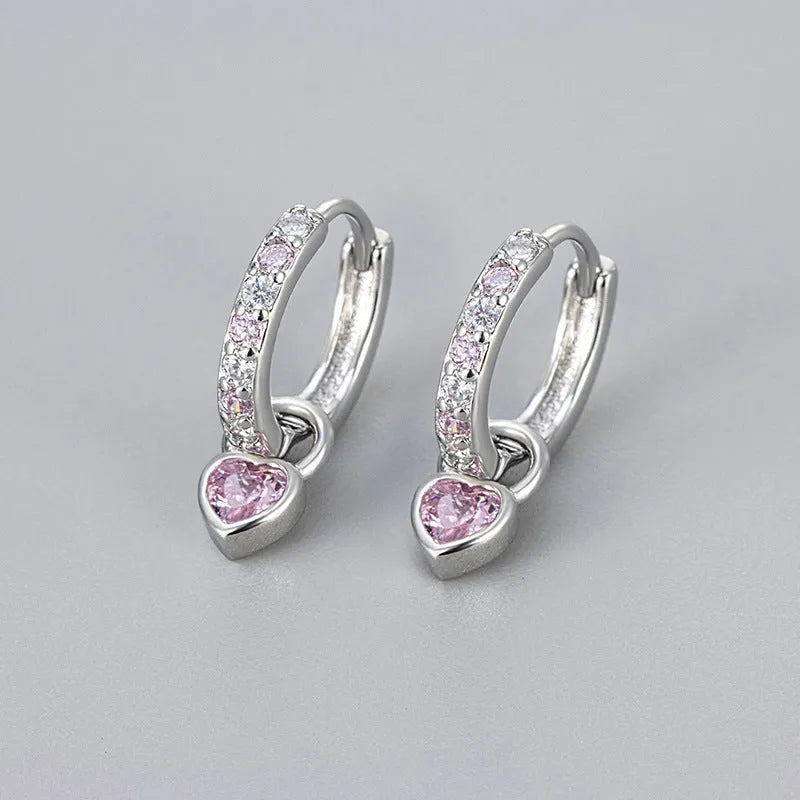 A pair of women's heart-shaped clip earrings with a coloured gemstone centre, available in gold or white gold colour metal.