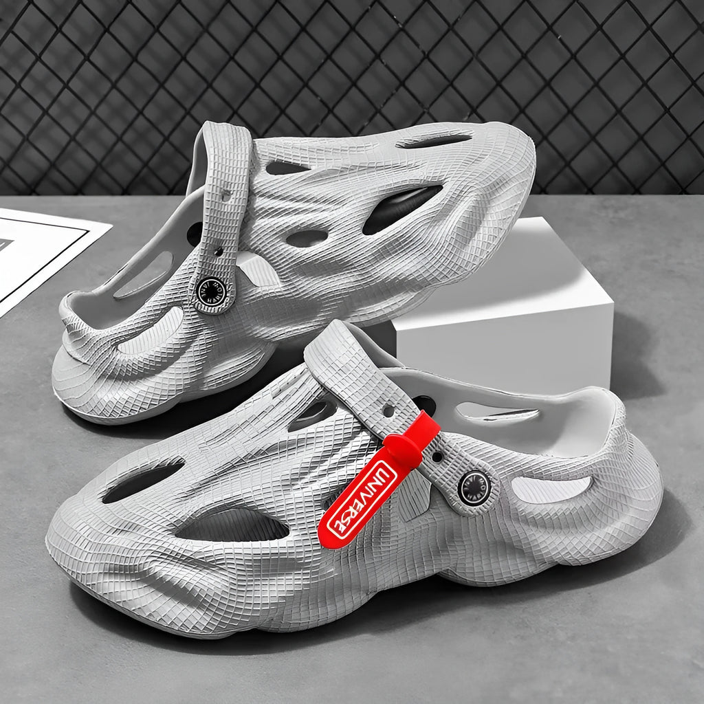 Men's grey coconut slippers with closed toe design and EVA construction on wooden deck