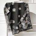 Grey imitation cashmere winter scarf with tassels laid flat, showing its long rectangular shape.
