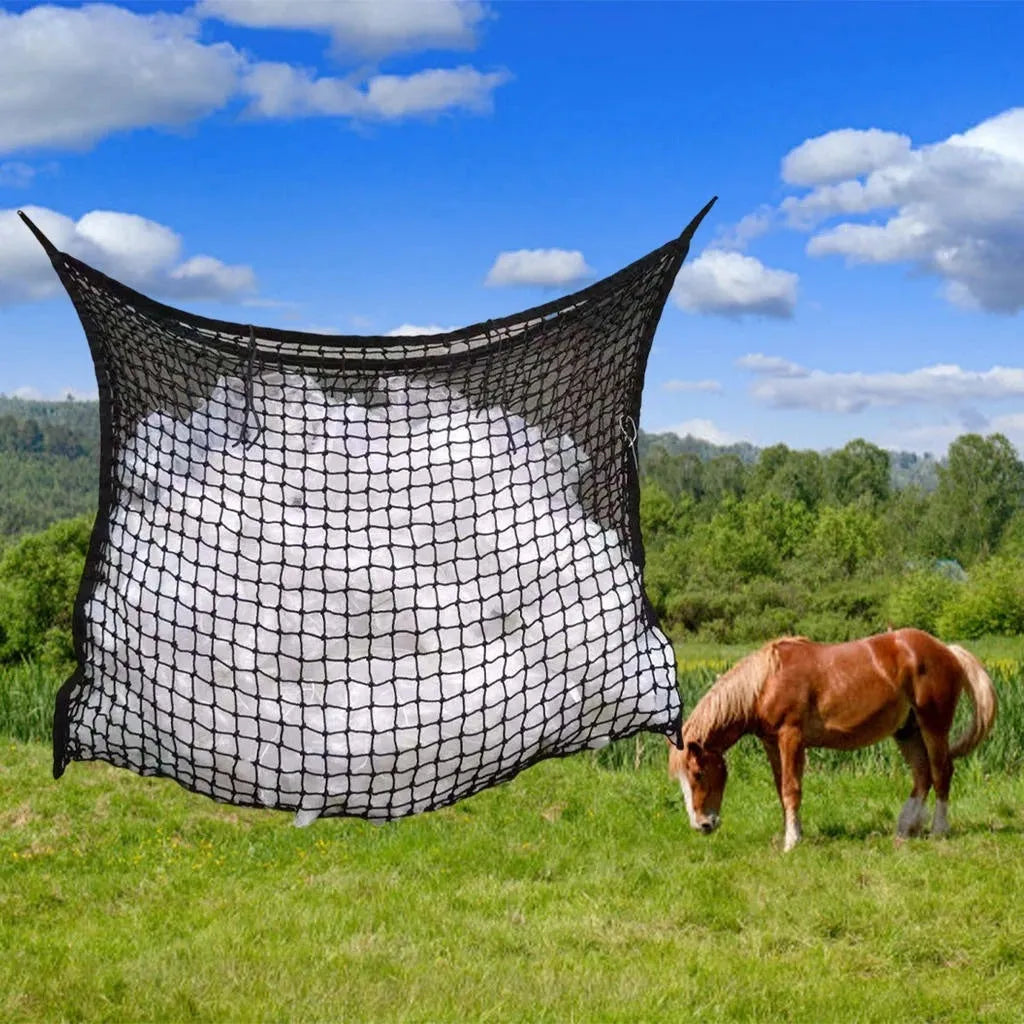 Black woven grid horse feeding bag hanging, filled with hay, for cattle or sheep.
