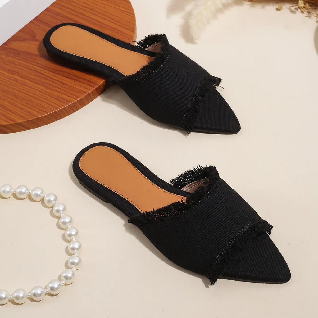 Women's denim flat slippers with leather lining and a tassel detail in various solid colours.