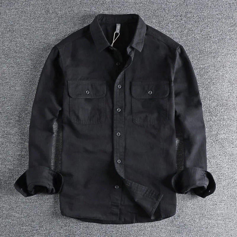 Man wearing a loose grey cardigan-style button-up shirt with long sleeves.