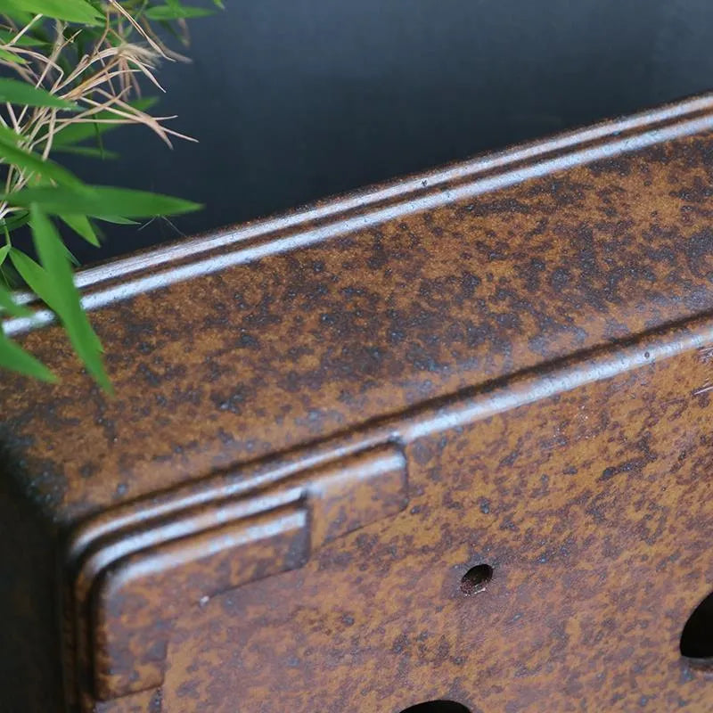 Rectangular purple sand bonsai pot with firewood burning texture on a floor.