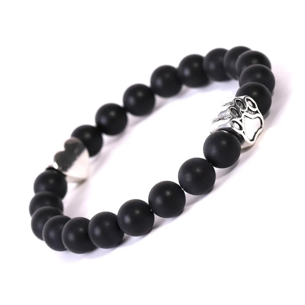 A round beaded stone bracelet in a Tiger Eye or Indian Agate style on a wrist.