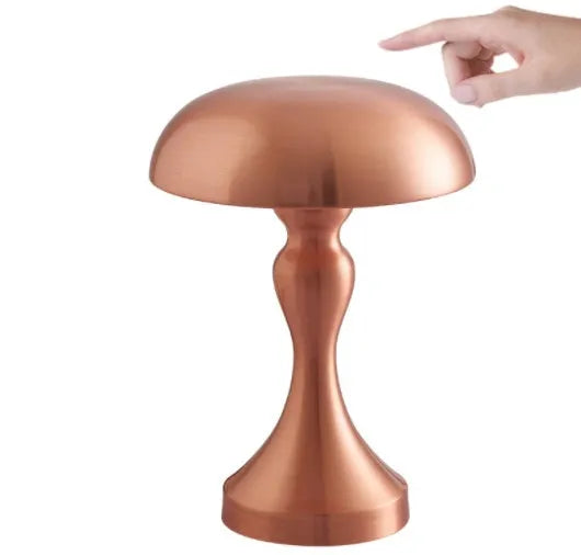 Metallic rechargeable touch desk lamp showing bronze, gold, and silver colour options on a wooden desk.