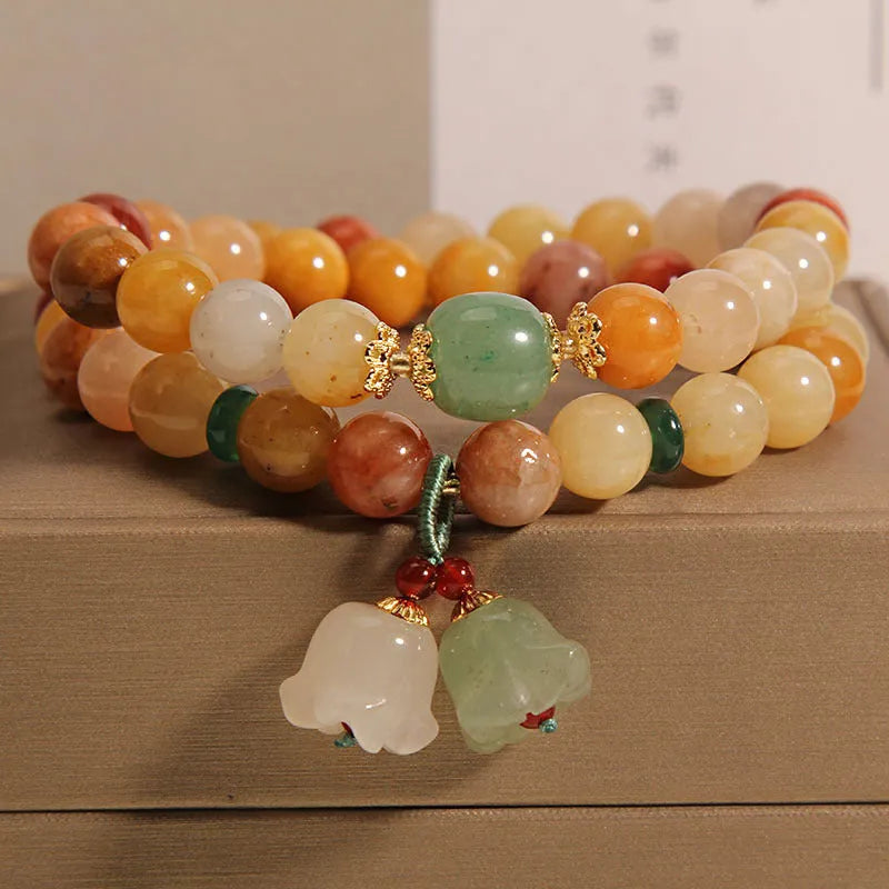 Natural green jinsi jade multi-layer bracelet for women with an orchid pendant charm on an elastic band.