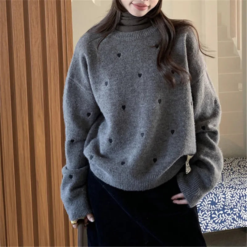 Women's loose grey acrylic pullover sweater with embroidery detail on the front, featuring long sleeves and a crew neck.