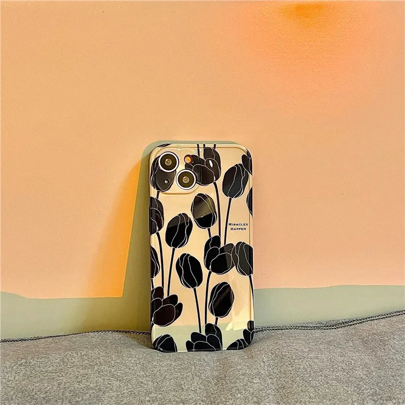 Black silicone iPhone case with a white tulip pattern design on the back.