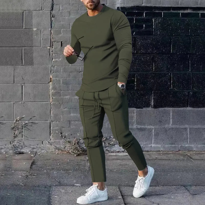 Man wearing a light grey round-neck long-sleeve t-shirt and matching trousers from a two-piece polyester suit set.