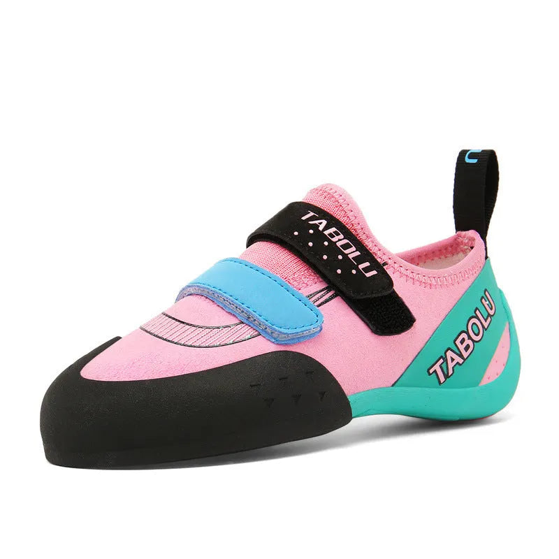 Pair of beginner rock climbing shoes with Velcro strap and black and red rubber outsole.