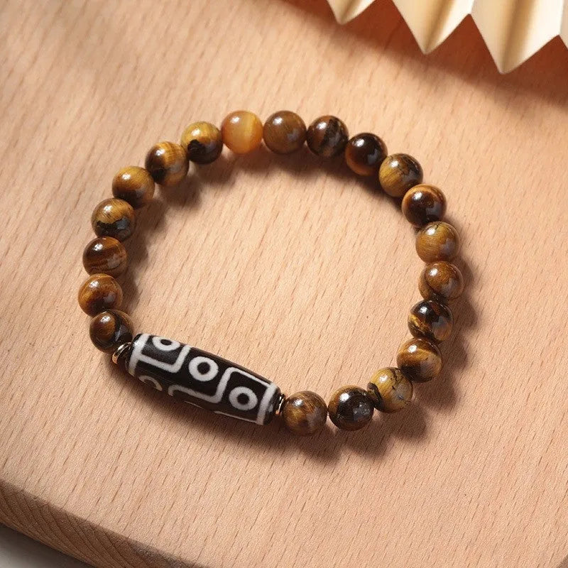 Close-up of a single-circle beaded Buddha rosary bracelet with tigereye dzi patterns on brown beads.