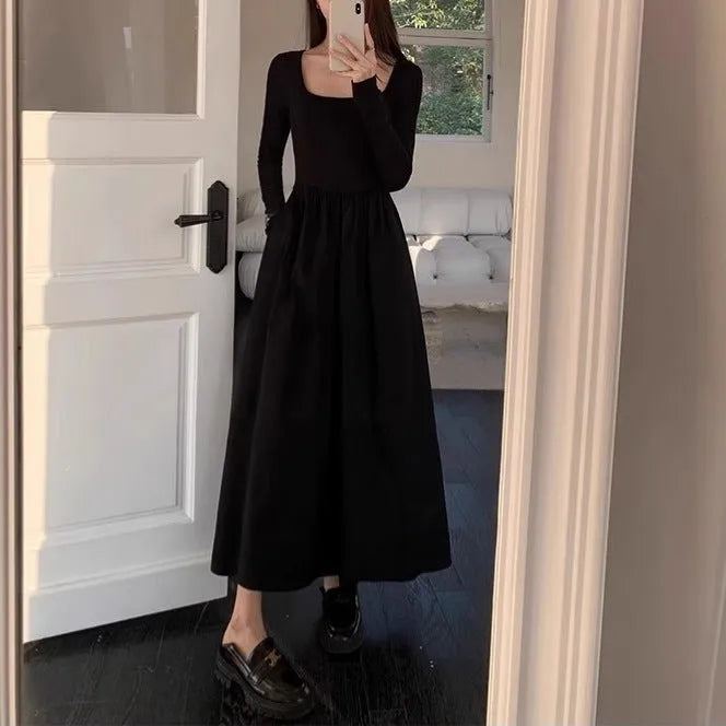 Women's black knitted dress with square collar and elastic waistband showing A-line long skirt design