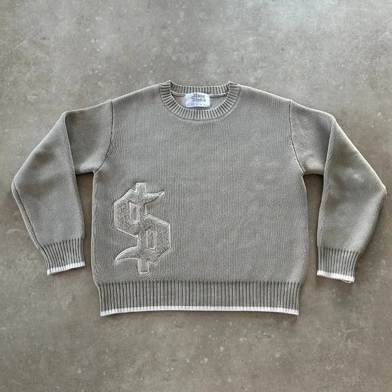 Grey loose-fitting jacquard knit pullover coat with long sleeves on a hanger.
