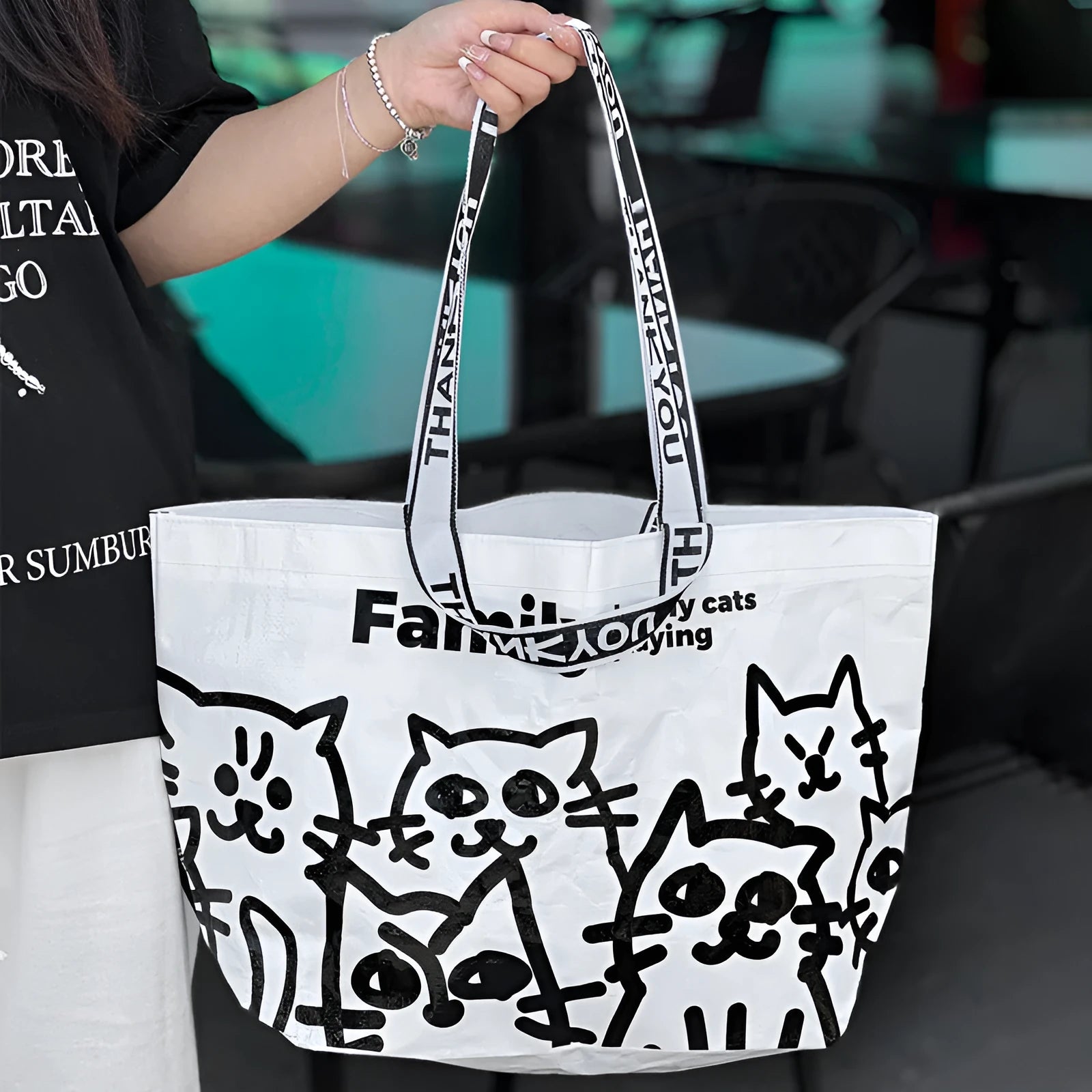 Blue waterproof woven handbag with colour printing showing clothing and cosmetics inside