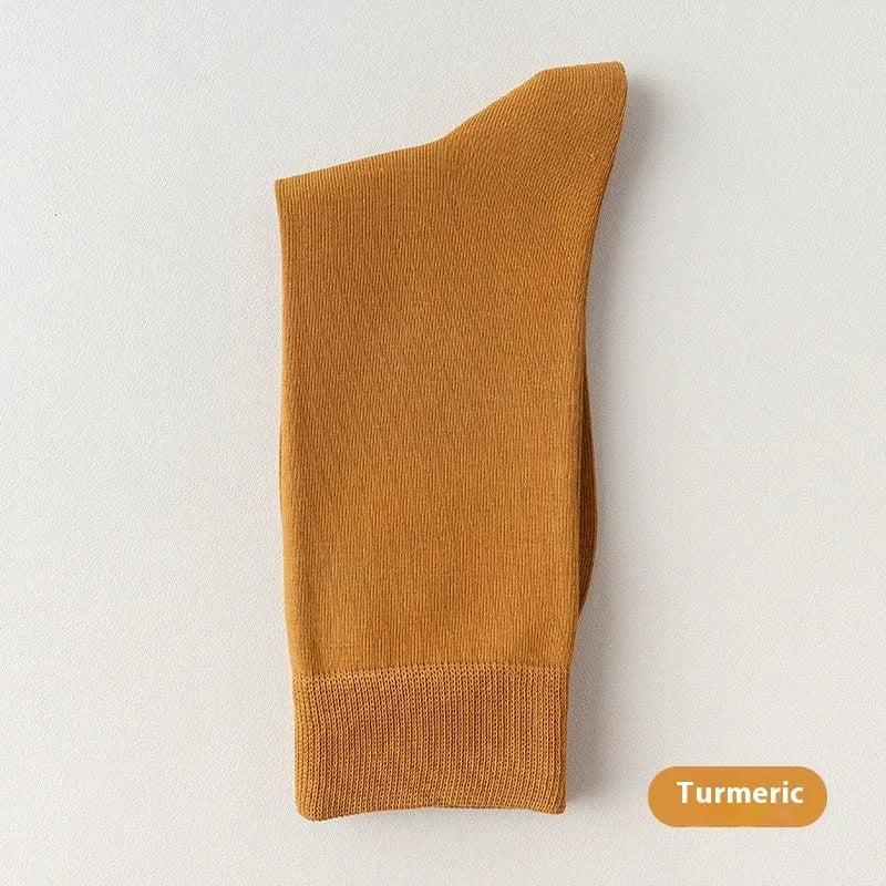 Mid-calf men's socks in solid colours made from combed cotton, shown in a stack.