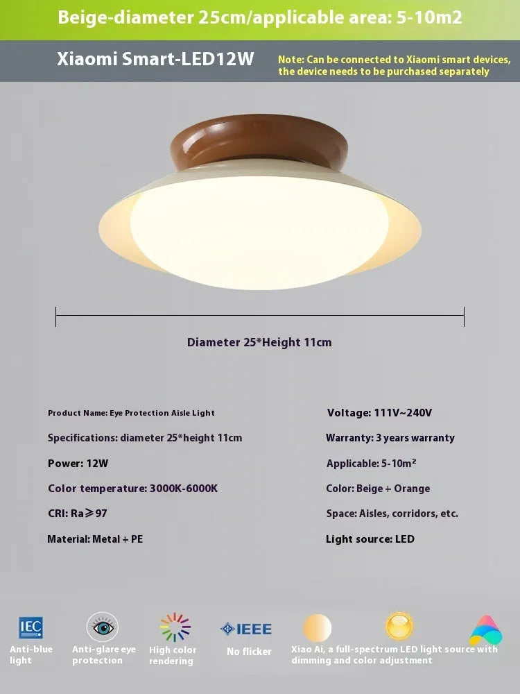 Modern minimalist flying saucer design ceiling lamp in cream yellow on a white ceiling.
