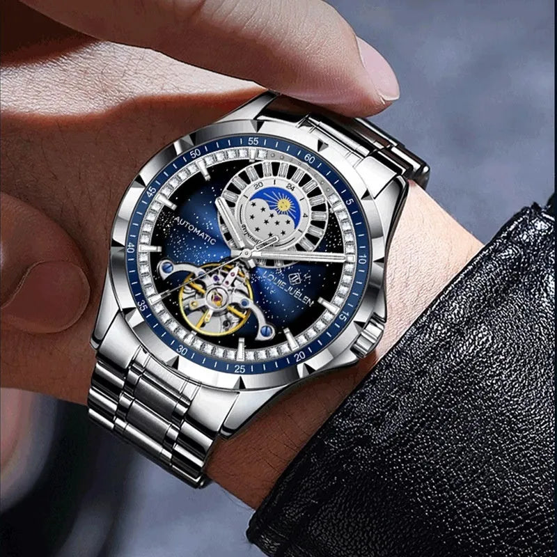 Silver automatic mechanical watch with blue dial on stainless steel bracelet showing transparent caseback