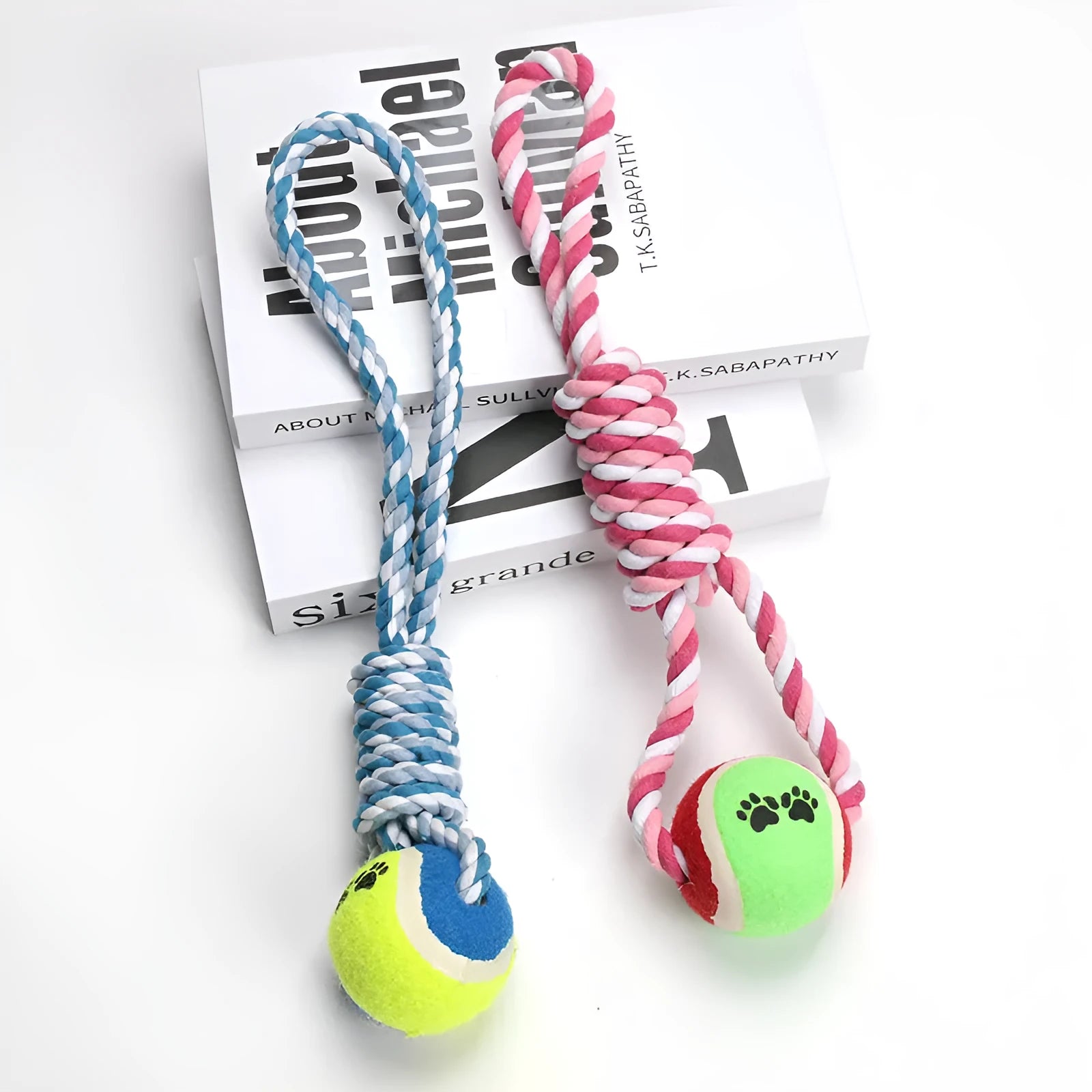 Braided red and white cotton rope dog tug toy for large breeds on a wooden floor.